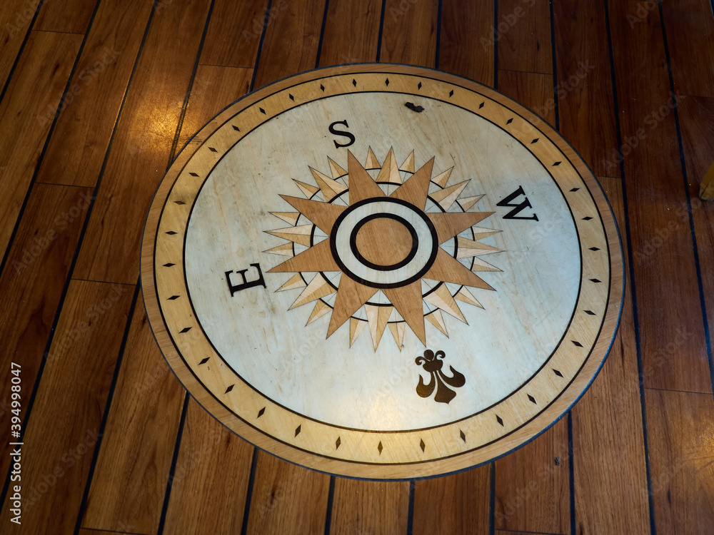 Compass directions wind rose on a wooden floor of a boat Compass directions wind rose on a wooden floor of a boat