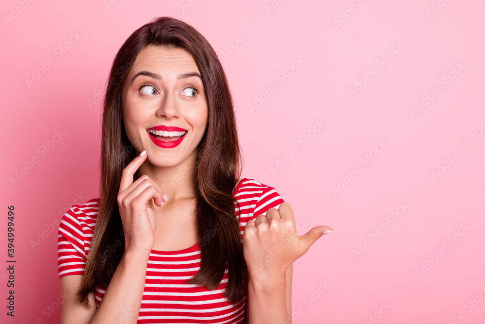 Portrait of beautiful charming happy young woman point look empty space hold finger chin isolated on pink color background Portrait of beautiful charming happy young woman point look empty space hold finger chin isolated on pink color background