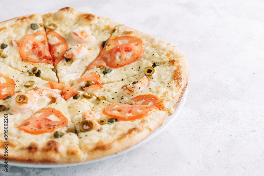 Pizza with tomatoes, cappers, shrimps, olives and parmesan close-up with place for text Pizza with tomatoes, cappers, shrimps, olives and parmesan close-up with place for text
