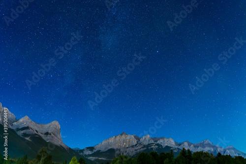 Starry sky with Rocky Mountains Mount Rundle in summer night.