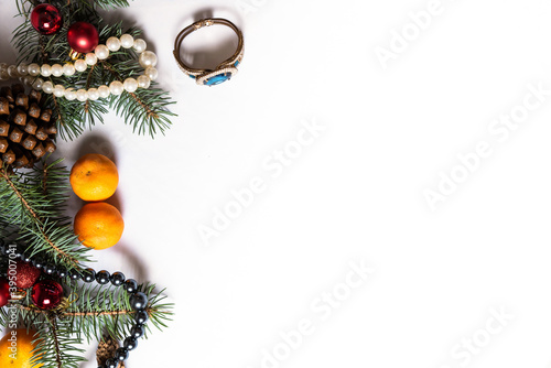 Christmas decoration and jewerly on white plain background.Pine cone, mandarins, new year toys, fir in winter composition with copy space.Hand rings and beads ornamentals during winter festive season.