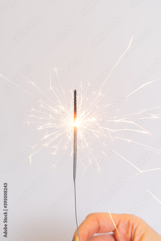 Obraz premium Bengal fire in hand. Hand holds burning sparkler symbol of magic at Christmas. Sparklers in hands, close up