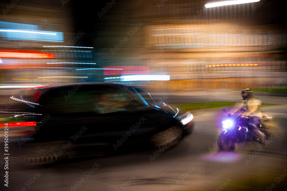 Dangerous city traffic situation with a motorcyclist and a car in motion blur