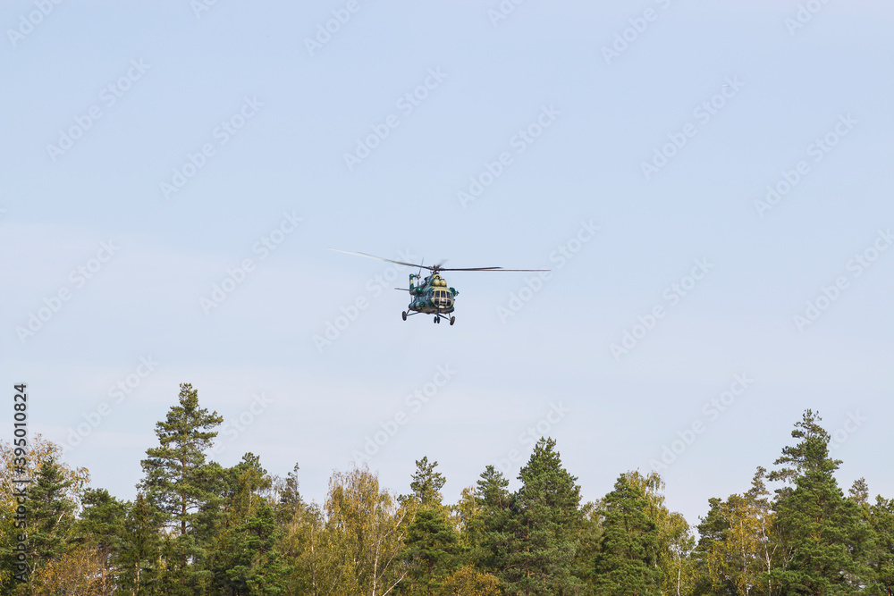 A military helicopter painted in camouflage color is flying high in the sky. Close up. A military helicopter painted in camouflage color is flying high in the sky. Close up.