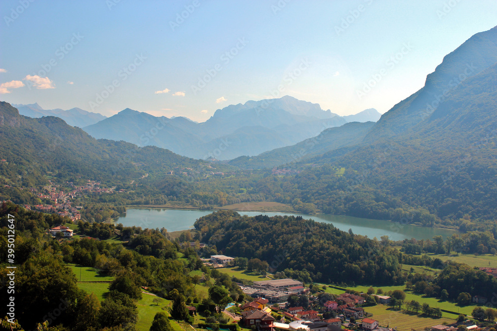 Beautiful panoramic view over a small Italian lake between the Alps on a summer day. Beautiful panoramic view over a small Italian lake between the Alps on a summer day.