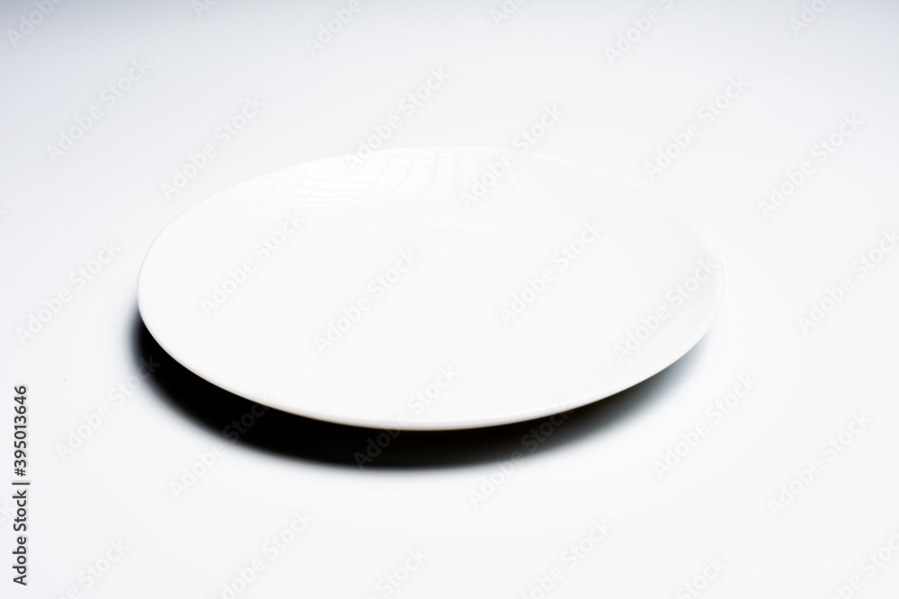 White plate with cutlery on white background White plate with cutlery on white background