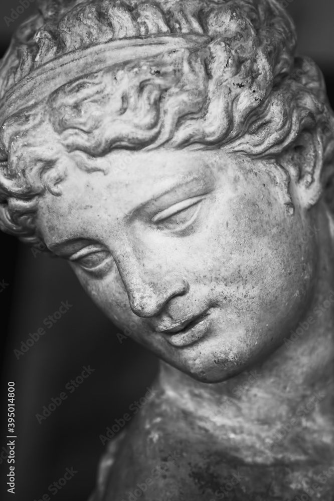 Close up face of Olympic goddess of love and beauty Aphrodite (Venus). Fragment of ancient statue. Vertical image.