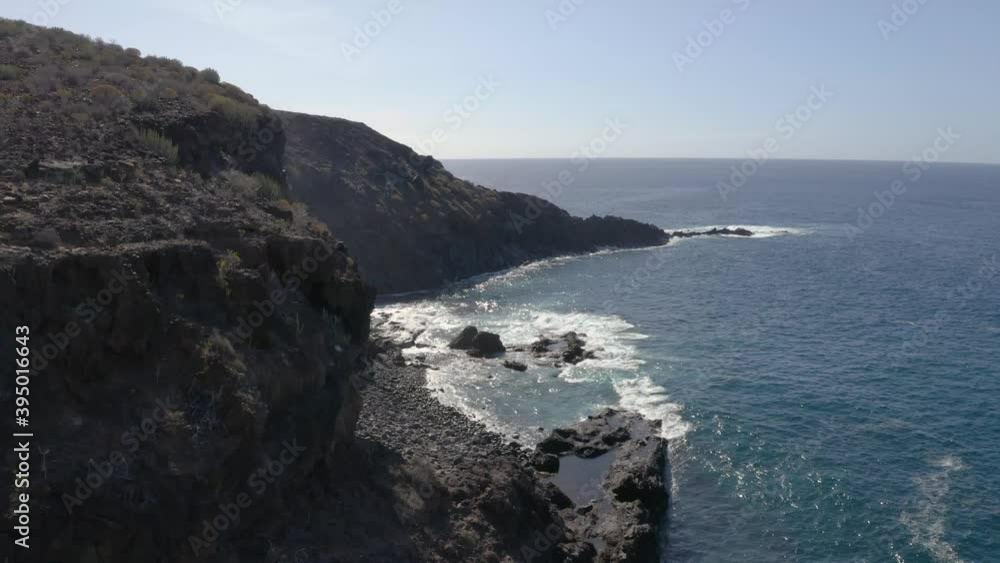 Aerial drone shot of dramatic coastline and cliffs with waves crashing in Tenerife Aerial drone shot of dramatic coastline and cliffs with waves crashing in Tenerife