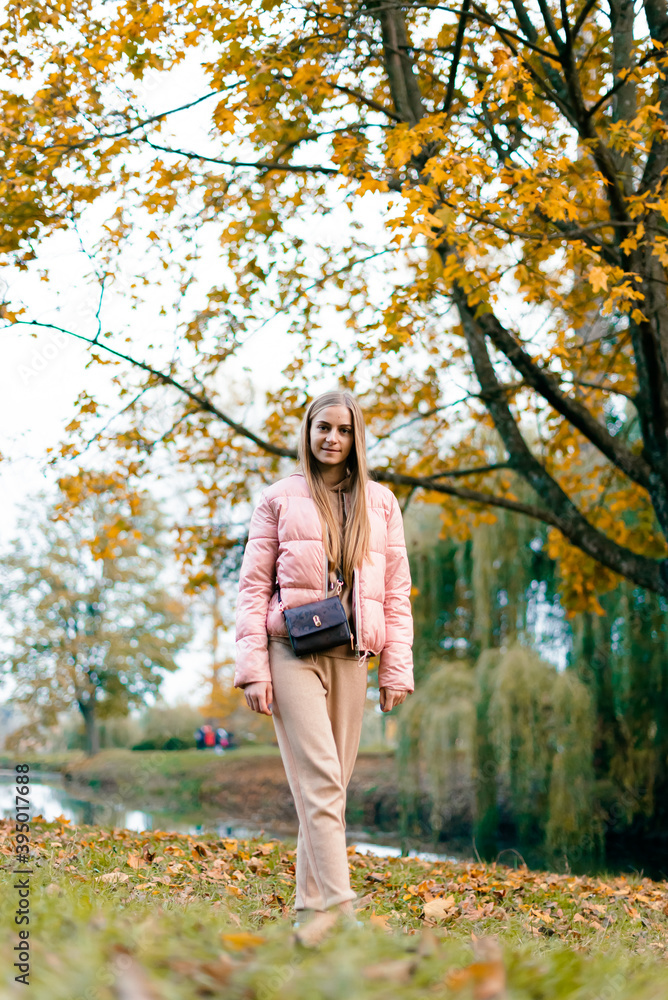 Attractive young woman enjoying her time outside in park with sunset in background. Beautiful young blond woman enjoying. Autumn Portrait of beautiful young woman. Attractive young woman enjoying her time outside in park with sunset in background. Beautiful young blond woman enjoying. Autumn Portrait of beautiful young woman.