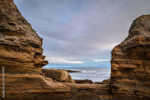 North Sea and Cliffs on Howick Coastline, on the rocky shoreline at Howick on the Northumberland coast, AONB, where there are several sandy coves