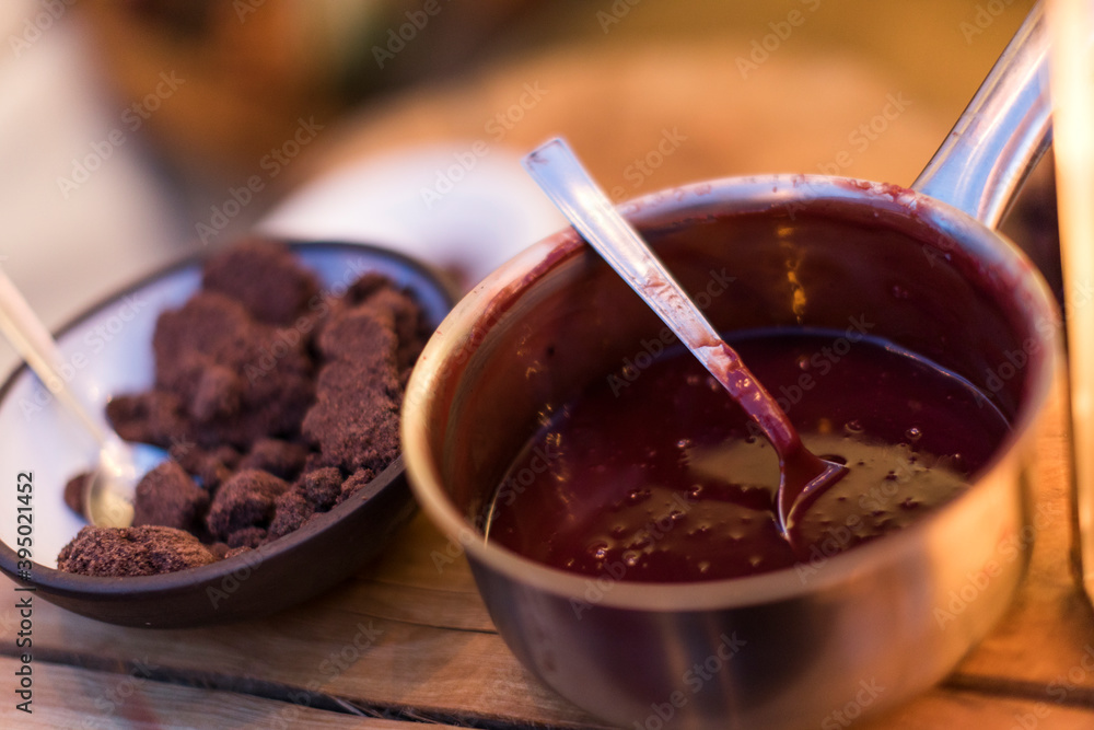 A pot of sauce and a bowl of some brown food. A pot of sauce and a bowl of some brown food.