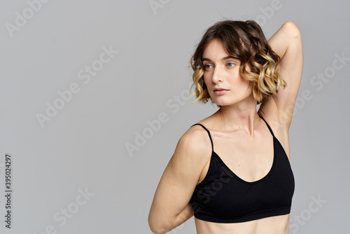 woman in short t-shirt goes in for sports on a gray background exercise exercise copy space