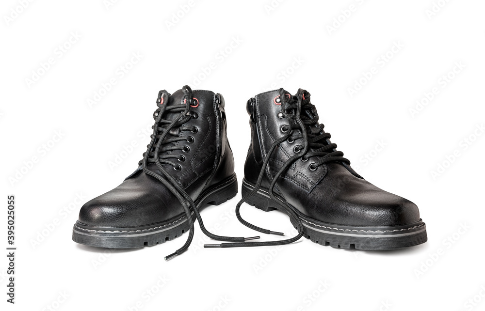 Black boots made of genuine leather with untied laces. Men's winter shoes on a white background.