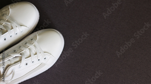 White sneakers on a dark background. top view, lifestyle.Sport. Place for text © Nelia