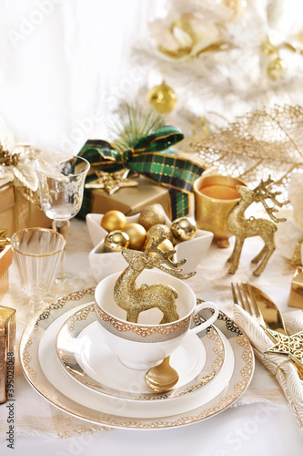 Christmas table setting in white and gold colors in glamour style photo