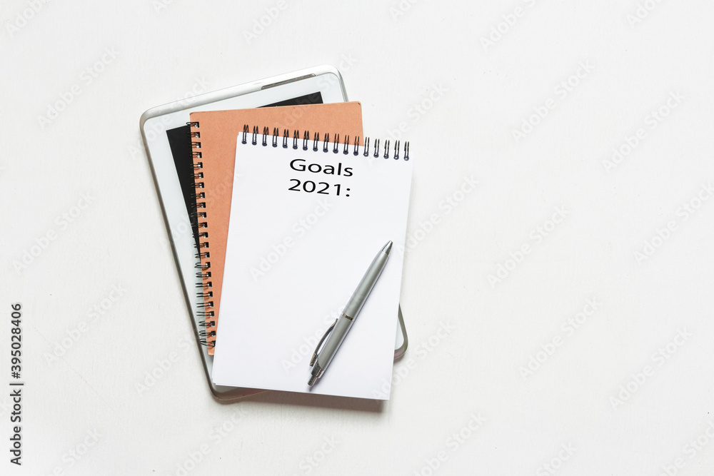 goal 2021 Top view flat lay of desktop and notepads writing down goals and plans. 2021 New Year's goal, plan,action text on notepad with office accessories. Business motivation, inspiration concept. goal 2021 Top view flat lay of desktop and notepads writing down goals and plans. 2021 New Year's goal, plan,action text on notepad with office accessories. Business motivation, inspiration concept.