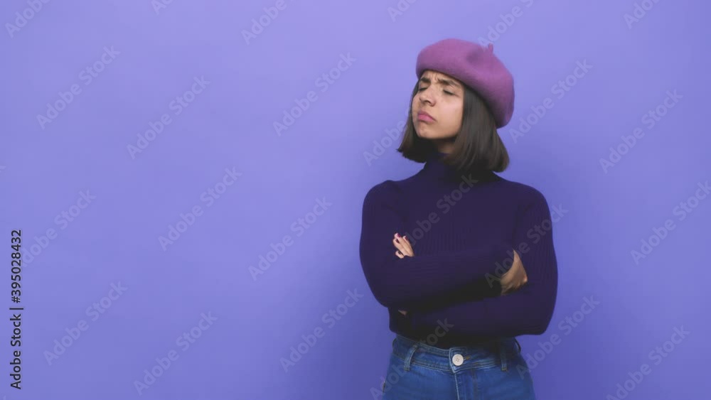 Young latin girl wearing a purple beret touching back of head, thinking and making a choice Young latin girl wearing a purple beret touching back of head, thinking and making a choice