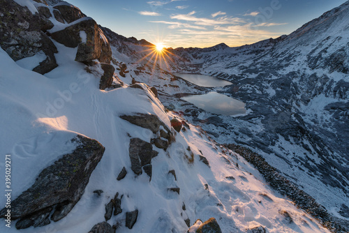 A tourist watches the sunset in the snow-capped winter Tatras