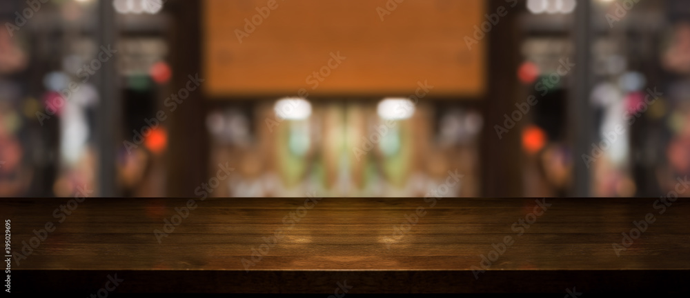 Empty wooden table top with lights bokeh on blur restaurant background.