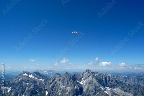 Plane over Watzmann Hocheck mountain, Bavaria, Germany