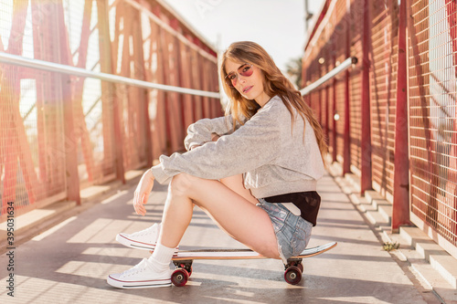 Skater girl sitting on a skateboard. Portraits of a young woman with a longboard © David CJ Photography