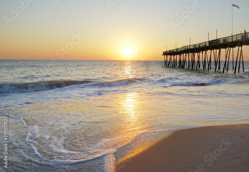 Avalon Pier and sandy beach at the Outer Banks of North Carolina at sunrise photo