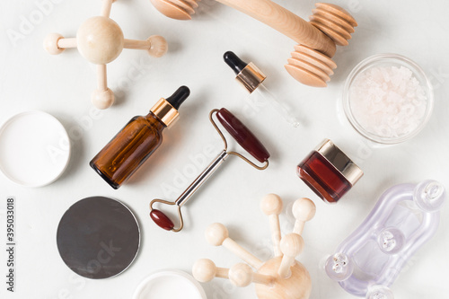 Zero waste organic spa cosmetics set on white background. top view of amber glass bottles and massage devices. Beauty products packing design. Image for spa salons