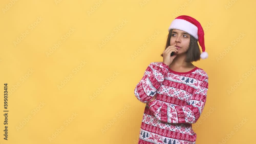Young latin woman celebrating christmas day thoughtful looking to a copy space covering mouth with hand Young latin woman celebrating christmas day thoughtful looking to a copy space covering mouth with hand