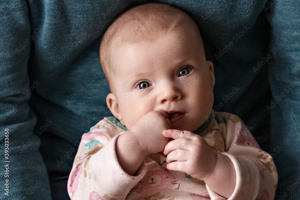 A small child is squeezed on his father's lap. A man holds the baby's legs with his palms. Father's day A small child is squeezed on his father's lap. A man holds the baby's legs with his palms. Father's day