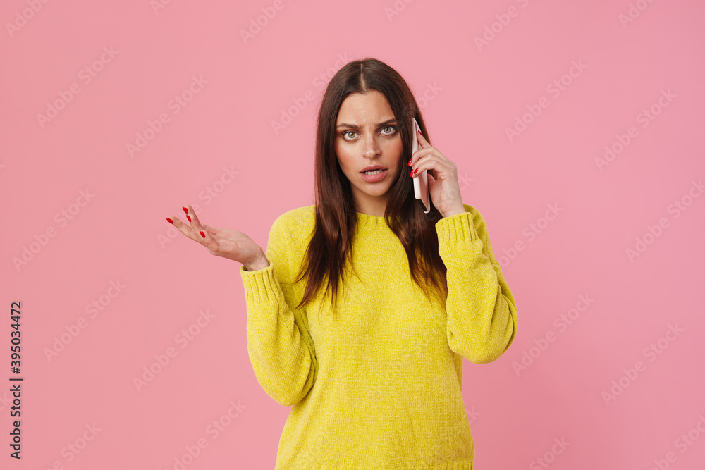 Displeased brunette girl gesturing and talking on cellphone Displeased brunette girl gesturing and talking on cellphone