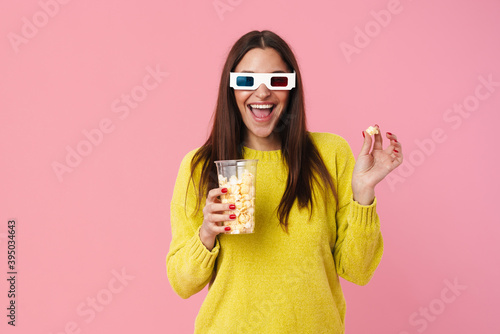 Happy nice girl in 3d glasses watching movie and eating popcorn