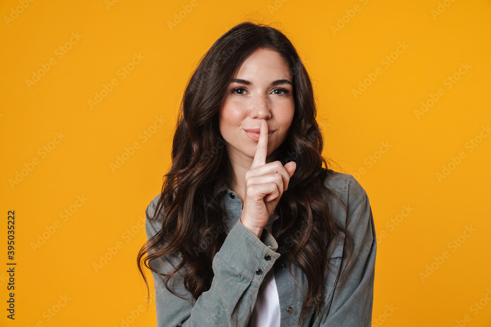 Pleased beautiful girl showing silence gesture on camera Pleased beautiful girl showing silence gesture on camera