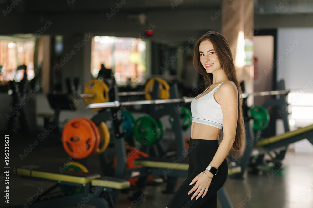 Attractive young woman in the gym. Brunette female go to gym after quarantine