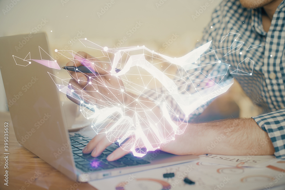 Handshake hologram drawing with businessman working on computer on background. Double exposure.