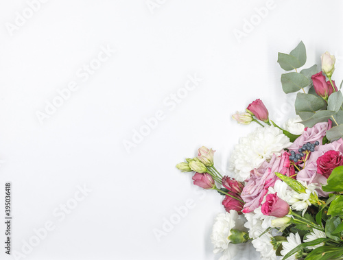 Flat lay with a bouquet of fresh flowers on a white background. Horizontally with space.template on a white background with a bouquet of Roses and chrysanthemums