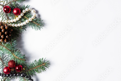 Flat lay christmas decoration and jewerly on white plain background.Pine cone, new year toys, fir in winter composition with copy space.Hand rings and beads ornamentals during winter festive season.