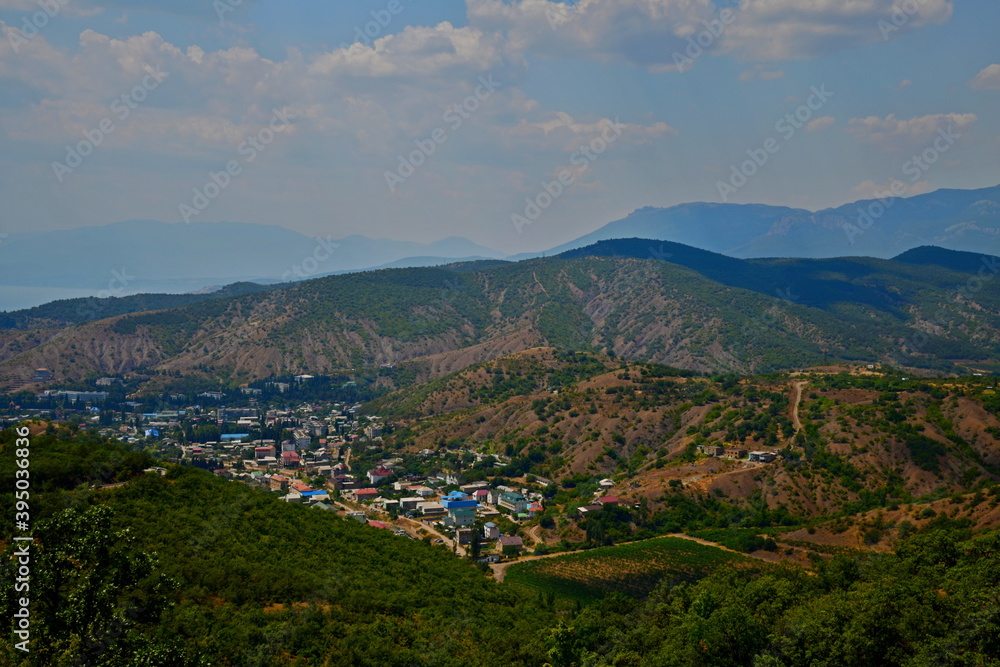Fototapeta premium landscape with a village in a valley, sky and clouds