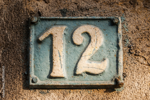 Old retro weathered cast iron plate with number 12 closeup