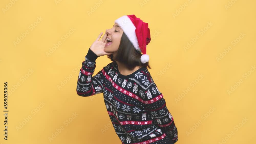 Young latin woman celebrating christmas day shouting and holding palm near opened mouth Young latin woman celebrating christmas day shouting and holding palm near opened mouth