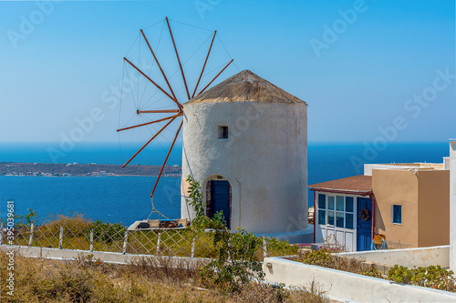 A view of a traditional windmill on the northern tip of the village of Oia  Santorini in summertime