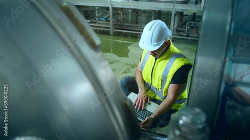 caucasian male senior engineering wearing safty uniform hand use laptop quailty control machinery checking in food processing factory industrial concept photo