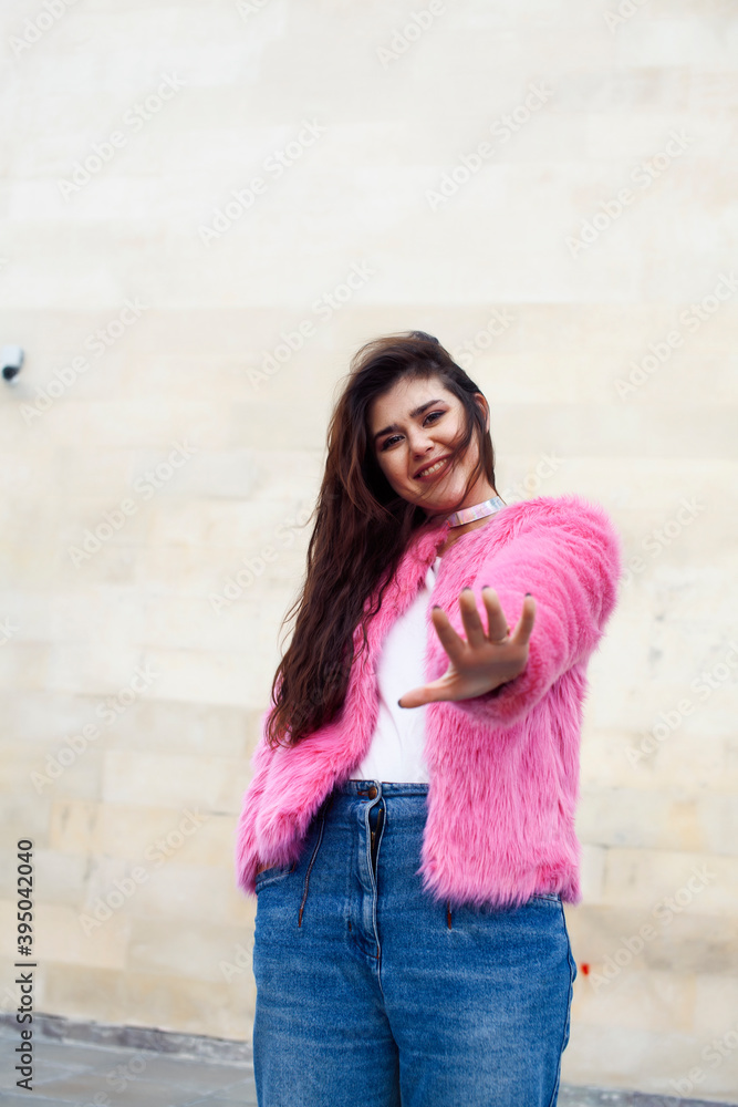 young cute girl teenager in pink fur coat gesturing hanging around outdoor , lifestyle people concept