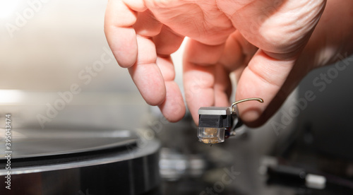 a man tune the cartridge for a turntable