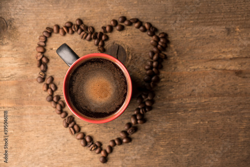 A coffee bean heart with a coffee mug in the middle