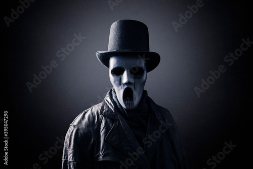 Ghostly figure with extra tall black vintage top hat in the dark