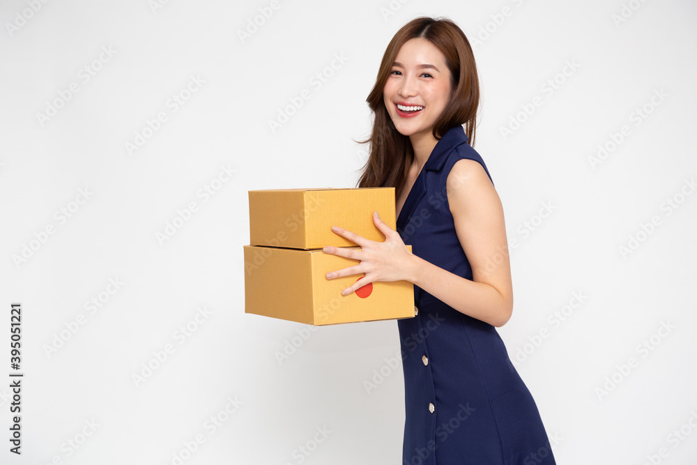 Happy Asian woman smiling and holding package parcel box isolated on white background, Delivery courier and shipping service concept Happy Asian woman smiling and holding package parcel box isolated on white background, Delivery courier and shipping service concept