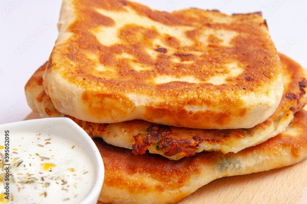 Three crunchy pies and white sauce as a stack Three crunchy pies and white sauce as a stack