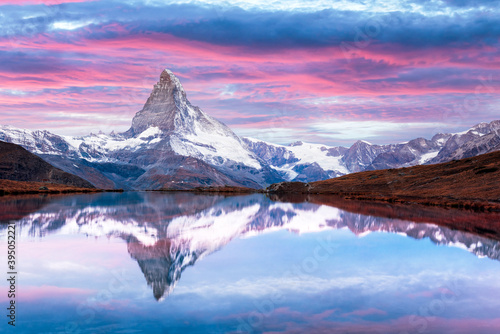 Picturesque landscape with colorful sunrise on Stellisee lake. Snowy Matterhorn Cervino peak with reflection in clear water. Zermatt, Swiss Alps