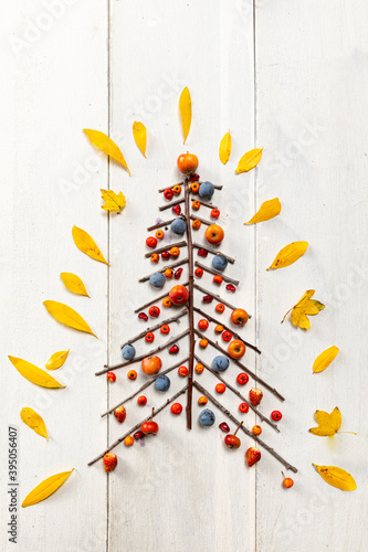 christmas tree with  white wood background and yellow leaves