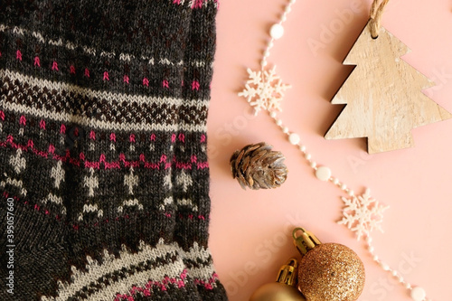 Fototapeta Naklejka Na Ścianę i Meble -  Warm cozy socks, various Christmas decorations and cinnamon sticks. Flat lay, pink background.